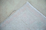 Distressed peach pile with hand knotted foundation of a vintage Oushak rug.
