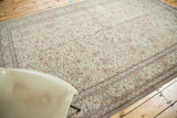 Distressed Kaisary carpet with faded grey-green field and allover orange floral motifs.