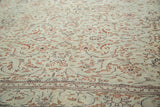 Distressed pile with faded reddish floral patterns and a border on a grey-green vintage Kaisary rug.