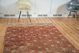 Vintage Turkish Oushak rug corner showing floral ribbon lattice and softened red hues.