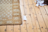 Ivory and gold shadow floral repeating panel design on a distressed Oushak rug.