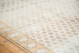 Decorative detail of distressed Oushak rug, ivory and gold repeating floral pattern with abrashes.