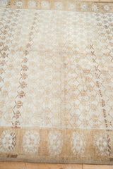 Distressed ivory and bronze shadow floral panels with abrashes on vintage Oushak rug.
