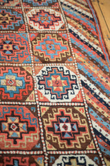 Alternating geometric gul motifs in madder red, sky blue, and coffee brown on a Kurdish runner.