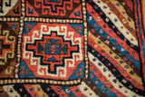 Interlocking geometric gul motif panel and vibrant tribal striped section of vintage Kurdish runner.