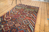 Vibrant, alternating geometric gul panels and striped borders on a vintage Kurdish tribal runner.