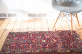 Luxurious cherry red field of a vintage Sarouk rug with vibrant floral bouquets.