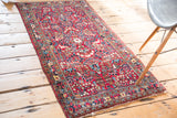 Vintage Sarouk rug's cherry red floral field and ornate navy blue border.