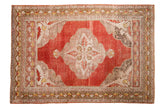 Distressed vintage Oushak rug, cinnabar red field, serrated ivory medallion, and charcoal spandrels.