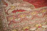 Distressed Oushak rug corner with saffron yellow floral motifs and textured abrash.