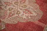 Serrated ivory medallion edge and distressed cinnabar red field on a vintage Oushak rug.