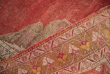Textured distressed Oushak rug showing cinnabar abrash field, geometric border, saffron and bronze.