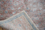 Distressed Kaisary rug corner showing muted floral motif and hand-knotted reverse.