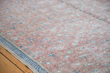 Distressed Turkish Kaisary carpet with faded floral motif in burnt raspberry, navy, and blue border.