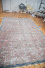 Distressed Kaisary carpet with burnt raspberry floral motifs and navy checkered border.