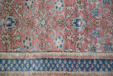 Distressed vintage Kaisary rug displays intricate burnt raspberry floral motifs and navy border.