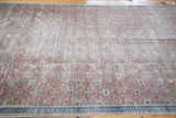 The distressed aesthetic and intricate floral motif of a vintage Turkish Kaisary rug.