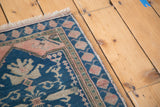 Vintage Oushak rug corner: teal blue field, ivory fruit motifs, dusty rose spandrels.