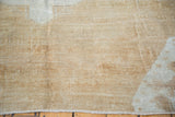 Distressed Oushak rug with varied pile, muted light brown and platinum tones.
