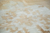 Distressed hand knotted Oushak rug showing faded tribal drawing and repiling in light brown.