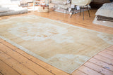Distressed Oushak carpet with faded tribal patterns and textured light gold, platinum shades.