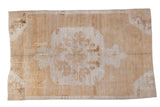 Distressed Oushak carpet with dramatic central medallion and primitive vine motifs.