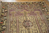 Distressed Oushak runner showing geometric patterns, mauve field, and light gold elements.