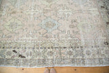 Muted geometric border and distressed texture of a vintage Oushak hand-knotted carpet.