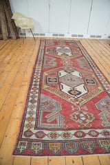Geometric border and fringe on distressed Oushak runner, with muted gold and brick red tones.