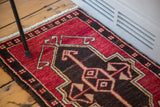 Geometric stylized pattern in red, charcoal brown, and tan from an Oushak rug corner.