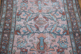 Distressed Lilihan runner's stylized flowers and central medallion in blush, red, and teal.