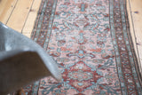 Distressed Lilihan runner detail with stylized floral medallions in blush, teal, and black cherry red.