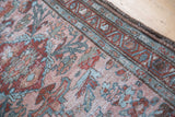Distressed hand woven runner with stylized flowers in blush rose, cherry red, and teal.