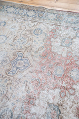 Close-up of distressed Turkish Kaisary carpet's muted blue, red scrolling floral pattern.
