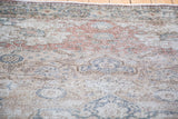 Distressed scrolling vine field with floral arrangements in faded burgundy, ivory, and grey.