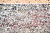 Distressed scrolling vine field with intricate floral motifs in dusty burgundy and soft blue.