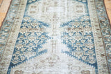 Distressed Malayer runner's pile, showcasing geometric patterns in faded blue and neutral tones.