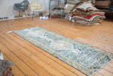Distressed Malayer runner showcasing geometric double medallions with faded blue and ivory.