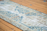 Distressed Malayer runner's intricate geometric patterns in blue, ivory, and brown hues.