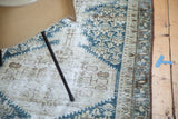 Distressed Malayer runner fragment showcasing intricate geometric patterns in navy, ivory, beige.