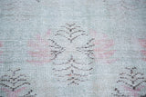 Distressed texture with abstract floral arrangements in light red and charcoal on a lime green field.