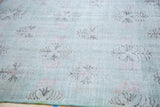Distressed Oushak rug pile, abstract charcoal and light red floral lattice on soft green.