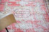 Distressed Oushak carpet showcasing faded cinnabar, ivory, and beige tones with soft patina.