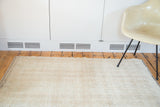 Faded ivory and beige patterns with distressed pile on the vintage Tulu rug edge.
