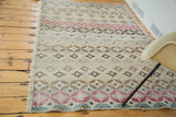 Distressed modern abstract Oushak rug corner with cranberry, aqua, gold, and brown geometric patterns.