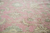 Distressed Oushak pile featuring faded cranberry and soft grey-green floral motifs.