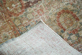 Hand-knotted foundation of distressed Sivas carpet with muted rust, gold, and charcoal tones.