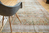 Distressed Sivas carpet showing faded floral lattice, terra cotta, teal, and gold abrashes.