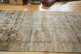 Distressed Sivas rug with fading floral lattice and prominent abrashes in muted tones.