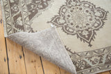 Lifted corner of vintage distressed Oushak runner, revealing hand knotted reverse and ivory medallion.